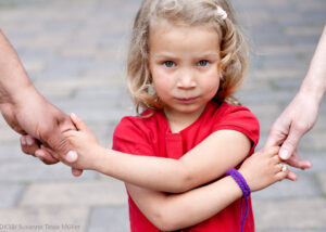 ein Kind hält die Hände von erwachsenen fest